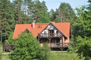 a house with an orange roof in a forest at Zakątek Sary in Jonkowo +25 photos