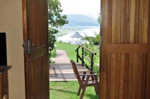 una puerta abierta a un porche con un banco de madera en Blue Haze Country Lodge, en Estcourt