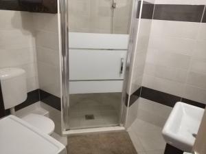 e bagno con doccia, servizi igienici e lavandino. di Art Apartments a Hajdúszoboszló