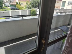 una porta scorrevole in vetro con vista su un balcone di Art Apartments a Hajdúszoboszló