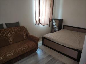 una camera con letto, divano e cassettiera di Art Apartments a Hajdúszoboszló