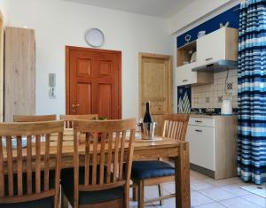 eine Küche mit einem Esstisch aus Holz und Stühlen in der Unterkunft La Dimora di Helios in Noto
