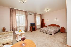 a bedroom with a bed and a table with a glass of wine at Hotel Anzas in Abakan