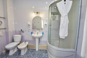 a bathroom with a toilet, sink and shower at Hotel Anzas in Abakan