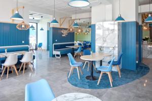 a restaurant with blue walls and tables and chairs at Blu Apartments in Sarbinowo