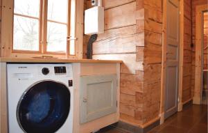 eine Waschmaschine und einen Trockner in einem Zimmer mit einer Steinmauer in der Unterkunft Gorgeous Home In Trans With Kitchen in Kvarnarp