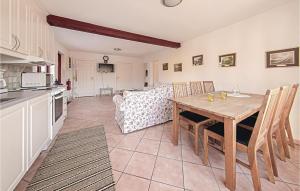 a kitchen and dining room with a table and chairs at Three-Bedroom Holiday Home In Tomelilla in Tomelilla +2 photos