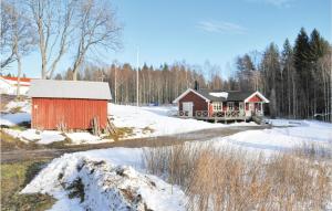 a red barn in the snow next to a road at Nice Home In Svanskog With Kitchen in Svanskog