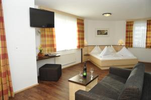 un soggiorno con divano e letto di Hotel Alpina a Kleinarl