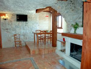 a living room with a fireplace and a table and chairs at Casa Rural La Bodeguilla in Alcalá del Júcar