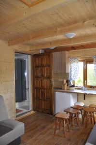 a kitchen in a log cabin with a table and chairs at Wiatrak in Ręboszewo