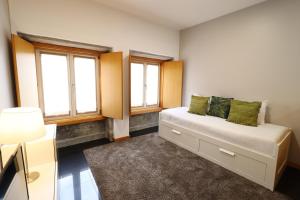 Un dormitorio con una cama y dos ventanas en Anjinho City Center, en Viana do Castelo