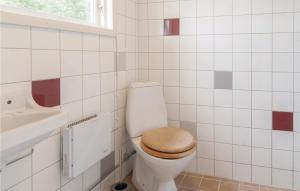 Baño blanco con aseo y asiento de madera en Amazing Home In Visby With Kitchen, en Fole