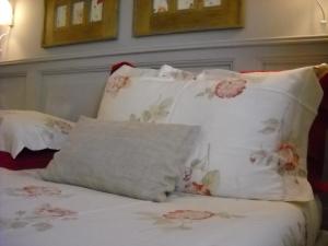 a bed with white sheets and pillows with pink flowers at La Casa del Giardiniere in Zero Branco +52 photos