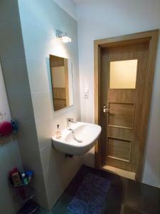 uma casa de banho com um lavatório e uma porta de madeira em Apartament 'Aleks' Tykocin em Tykocin