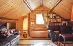 Amazing Home In Fgelmara With Sauna في Fågelmara: غرفة معيشة مع أثاث جلدي في كابينة خشب