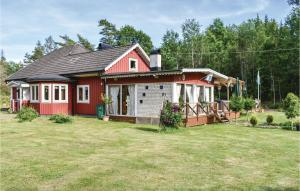 een rood huis met een tuin ervoor bij Amazing Home In Fgelmara With Sauna in Fågelmara