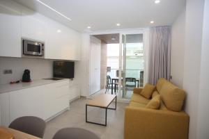Il comprend un salon avec un canapé et une cuisine. dans l'établissement Iberflat APARTAMENTOS LOS PINOS, à Benicàssim