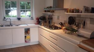 a kitchen with a sink and a stove top oven at Begijnhof 13 Holiday Home in Zuienkerke