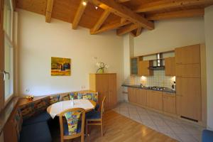 a kitchen with a table and a dining room at Garni Sonnblick in Naturno