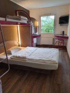 
a bedroom with a bed and a desk at ibis budget Erfurt Ost in Erfurt
