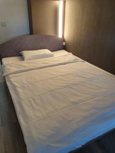 
a bed with a white comforter and pillows at ibis budget Erfurt Ost in Erfurt
