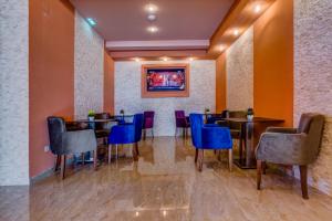 a restaurant with tables and chairs and a painting on the wall at Adriatik Lux Apartments in Budva