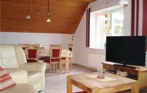 a living room with a flat screen tv and a table at 2 Bedroom Pet Friendly Apartment In Mirow Ot Qualzow in Qualzow