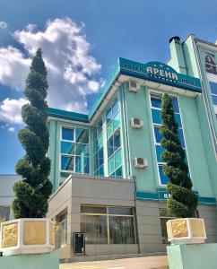 um edifício azul com uma árvore em frente em Arena Tarnovo Hotel em Veliko Tŭrnovo