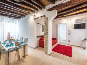 uma sala de estar com uma mesa e um sofá vermelho em Appartamento Il Lillà em Cagliari