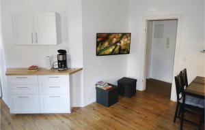 a kitchen with white cabinets and a table in a room at 2 Bedroom Awesome Apartment In Wismar in Wismar