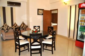 a dining table and chairs in a living room at The Bhopal Grande in Bhopal