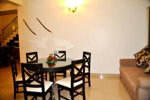 a dining room with a table and chairs and a couch at The Bhopal Grande in Bhopal