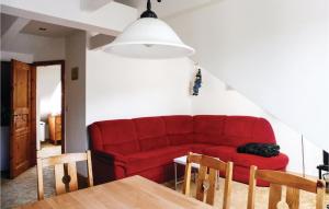 a living room with a red couch and a table at Stunning Apartment In Sankt Andreasberg in Sankt Andreasberg