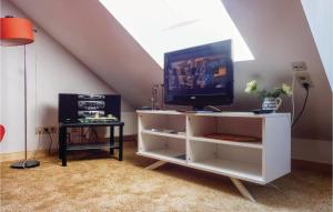 ein weißes Entertainment-Center mit einem TV und einem Tisch in der Unterkunft Amazing Apartment In Sankt Andreasberg With Kitchenette in Sankt Andreasberg