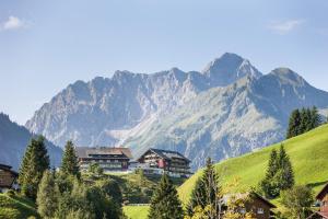 a village with a mountain in the background at Haller's Geniesserhotel in Mittelberg