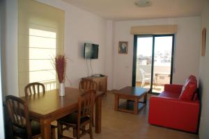 a living room with a table and a red couch at Apartamentos Plaza in Nerja