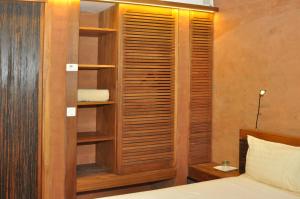 a bedroom with a bed and a wooden book shelf at Hotel Le Djoloff in Dakar