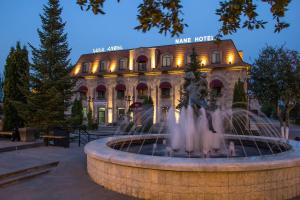 a building with a fountain in front of a building at Nane Hotel in Gyumri