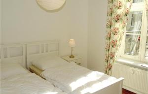 two beds in a white bedroom with a window at 2 Bedroom Awesome Apartment In Wismar in Wismar