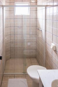 uma casa de banho com um chuveiro, um WC e um lavatório. em Hotel Scoz em Pouso Redondo