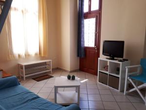 エルムポリにあるErmoupolis, Syros City Apartmentsのソファとテレビのあるリビングルーム