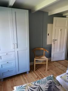 - une chambre avec un lit, une commode et une chaise dans l'établissement Østigård 1810, à Åndalsnes