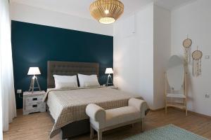 a bedroom with a large bed and a chair at #FLH - Boho Chic Apartment, Agia Sofia District in Thessaloniki