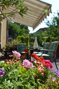 a patio with chairs and flowers and an umbrella at Haus Lindenhofer in Emmersdorf an der Donau