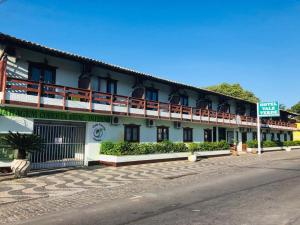 a white building with balconies on a street at Hotel Vale Verde in Porto Seguro