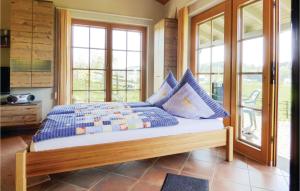 a bedroom with a bed with blue pillows on it at Amazing Home In Krperich-obersgegen With Sauna in Obersgegen