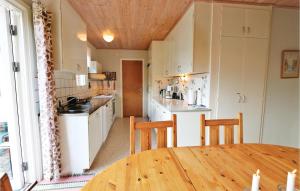 a kitchen with a wooden table and a dining room at 3 Bedroom Gorgeous Home In Yngsjö in Yngsjö