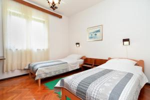Cette chambre comprend 2 lits et une fenêtre. dans l'établissement Apartment Milka 1950, à Fažana