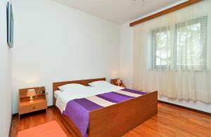 sypialnia z dużym łóżkiem i oknem w obiekcie Apartment Milka 1950 w Fažanie